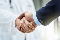 Cropped shot of a doctor shaking hands with a businessman